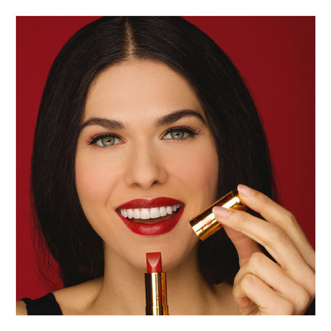 brunette woman smiling with red lipstick on red background