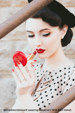 Woman applying Red Velvet Bésame's lipstick with matching Red Velvet Bésame's nail polish
