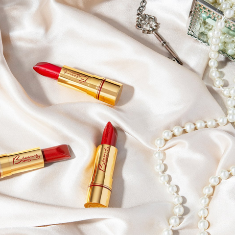 Bésame Cosmetics Red Lipsticks next to Pearl Necklace