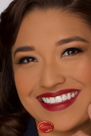 Woman smiling wearing Bésame Cosmetics Red Lipstick and Cake Mascara