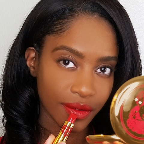 Woman applying Bésame Cosmetics Red Lipstick